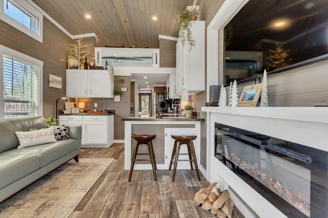 a kitchen with stainless steel appliances granite countertop a stove top oven a sink dishwasher a dining table and chairs with wooden floor