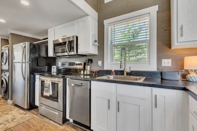 a kitchen with stainless steel appliances granite countertop a sink stove and refrigerator