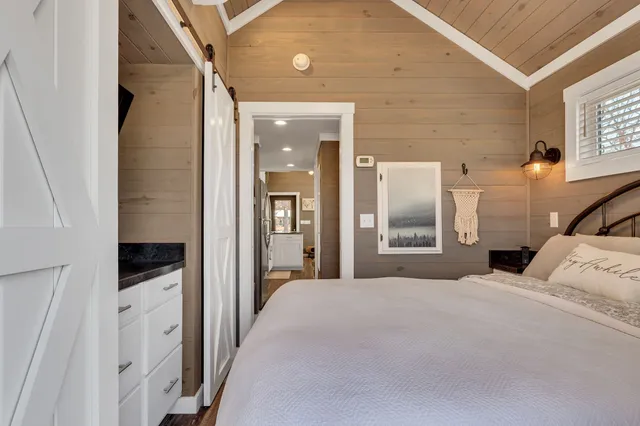 a bedroom with a bed and a large mirror