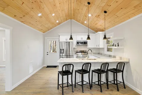 a kitchen with granite countertop a table chairs sink and cabinets