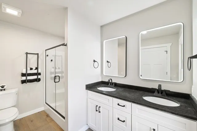 a bathroom with a granite countertop sink mirror toilet and shower