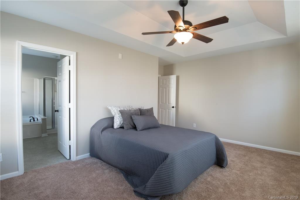 11712 Kennon Ridge Lane Huntersville, NC 28078 - Photo 17 of 31 a bedroom with a bed and a ceiling fan