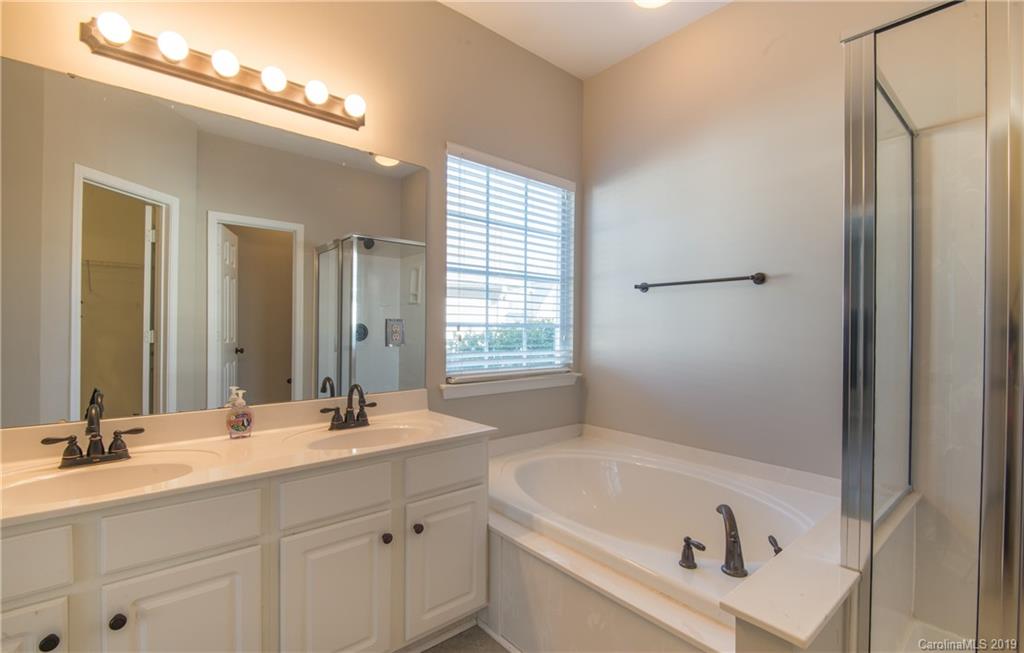 11712 Kennon Ridge Lane Huntersville, NC 28078 - Photo 20 of 31 a bathroom with a tub a sink and mirror
