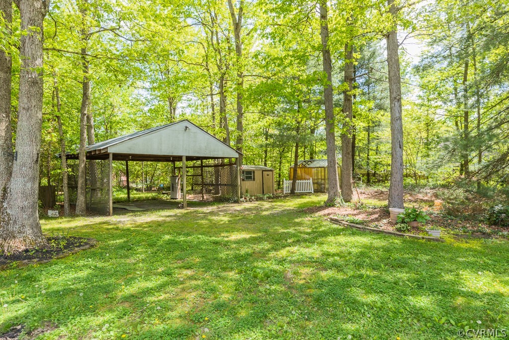 10801 Genito Road Chesterfield, VA 23832 - Photo 42 of 46 a backyard of a house with table and chairs under an umbrella