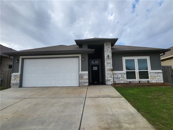 a front view of a house with a yard and garage