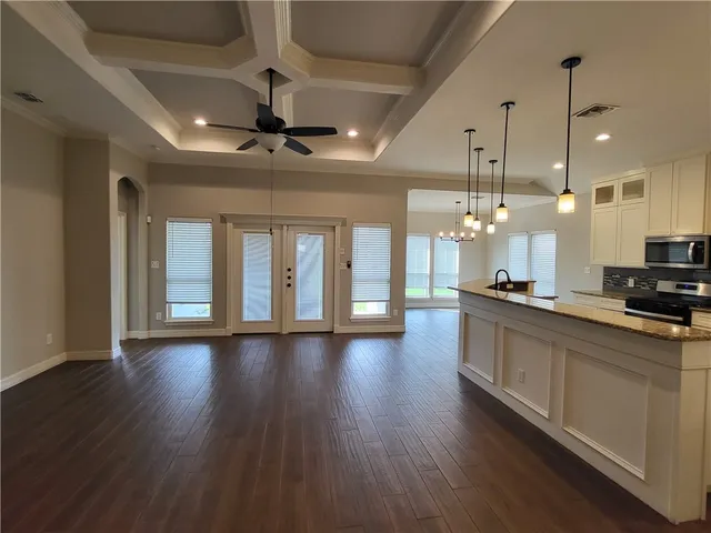 a large kitchen with hardwood floor a sink and a counter top space