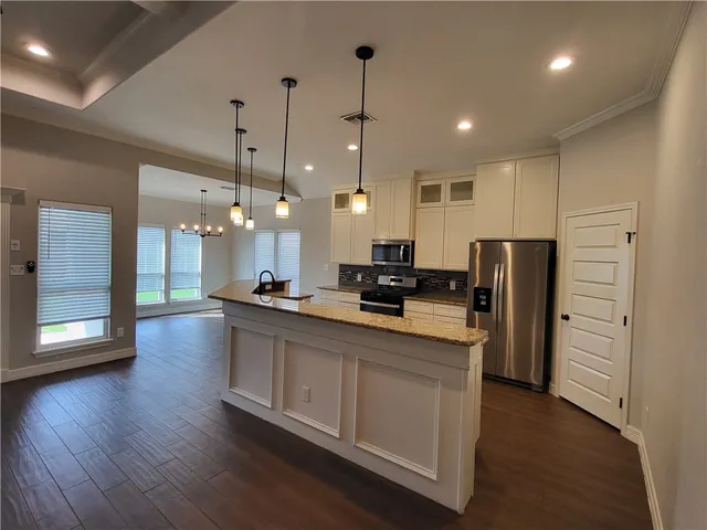 a large kitchen with stainless steel appliances kitchen island a large counter space a sink appliances and cabinets