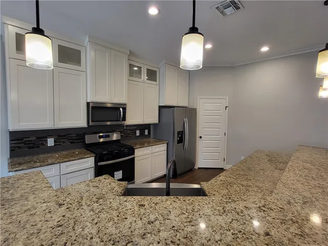 a kitchen that has cabinets stove and refrigerator