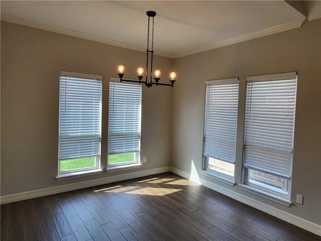 a view of a livingroom with wooden floor and a large window