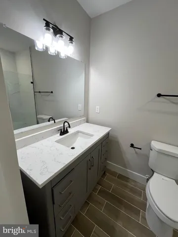 a bathroom with a sink toilet and a mirror