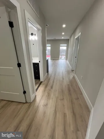 a view of a hallway with wooden floor and staircase