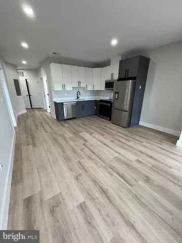 a view of kitchen with refrigerator sink and cabinets