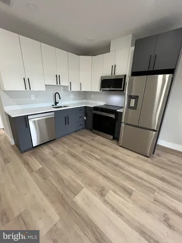 a large kitchen with a stove a sink and a refrigerator