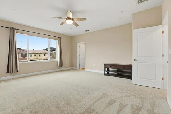 an empty room with windows and fan