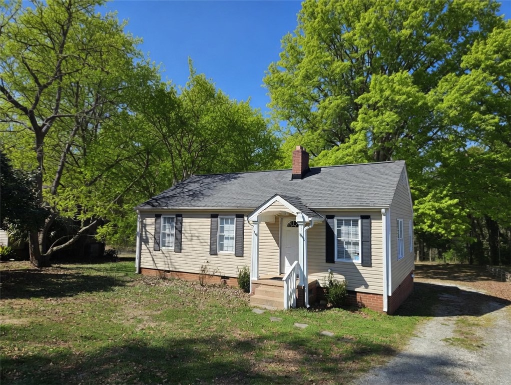 237 Pine Lane Anderson, SC 29621 - Photo 3 of 23 A charming cottage, framed by verdant trees, offers a cozy retreat with its classic facade.