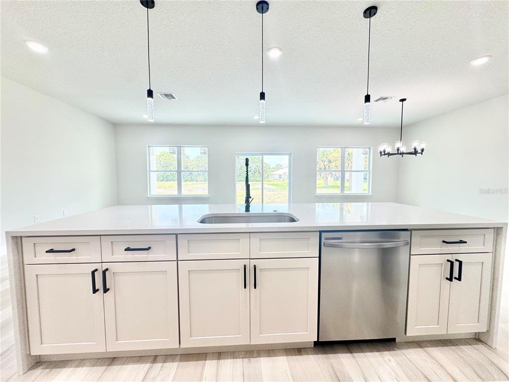 1690 Hamilton Avenue Southwest Palm Bay, FL 32908 - Photo 19 of 56 a kitchen with kitchen island white cabinets and white appliances