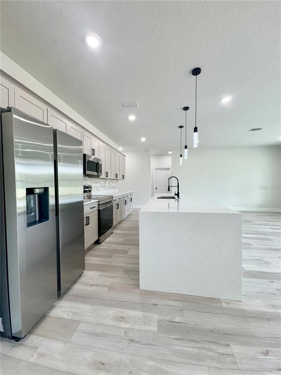 1690 Hamilton Avenue Southwest Palm Bay, FL 32908 - Photo 25 of 56 a large white kitchen with a refrigerator a kitchen island a stove and a sink