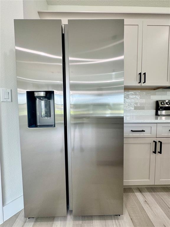 1690 Hamilton Avenue Southwest Palm Bay, FL 32908 - Photo 29 of 56 a kitchen with a refrigerator and white cabinets