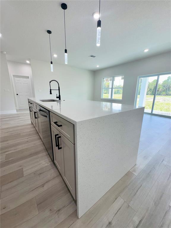 1690 Hamilton Avenue Southwest Palm Bay, FL 32908 - Photo 31 of 56 a large kitchen with stainless steel appliances a large counter top a sink a refrigerator and a window