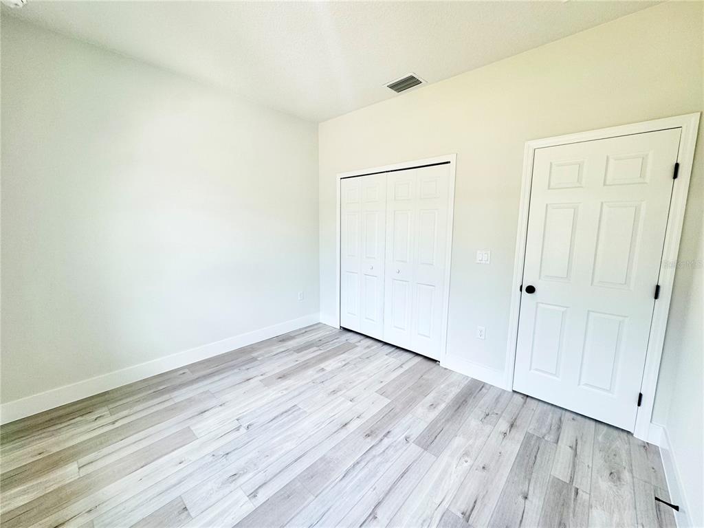 1690 Hamilton Avenue Southwest Palm Bay, FL 32908 - Photo 47 of 56 a view of an empty room with wooden floor