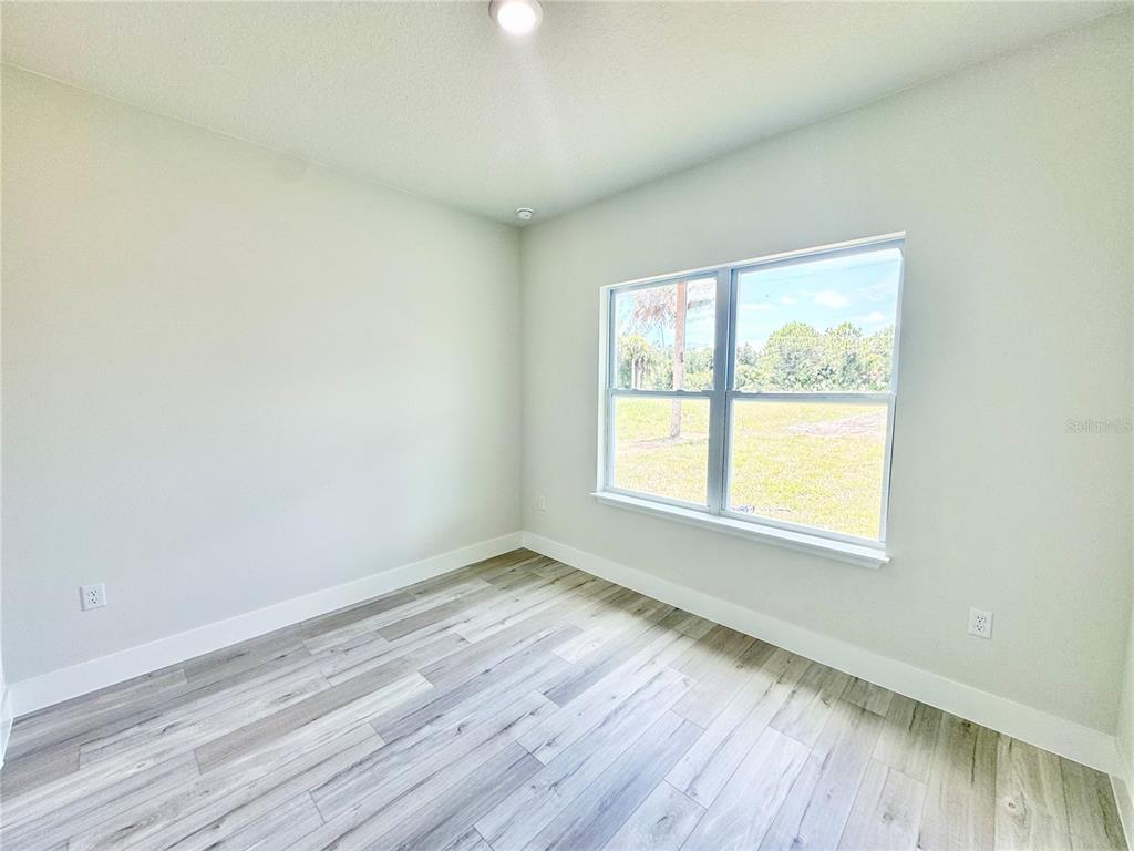 1690 Hamilton Avenue Southwest Palm Bay, FL 32908 - Photo 49 of 56 an empty room with wooden floor and windows