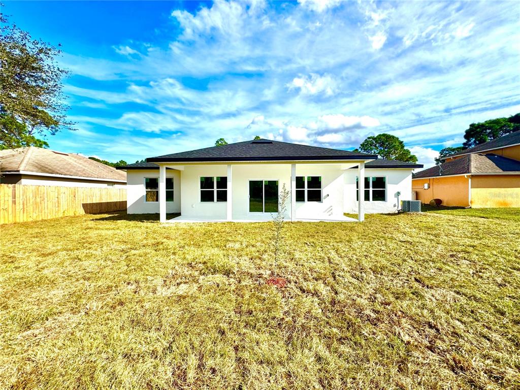1690 Hamilton Avenue Southwest Palm Bay, FL 32908 - Photo 8 of 56 a white house with a big yard and large tree