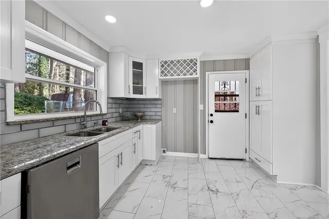 a kitchen with stainless steel appliances granite countertop a sink and a stove