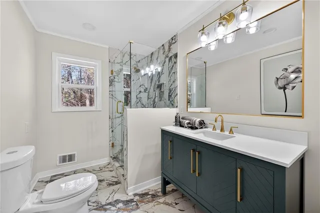 a bathroom with a toilet a sink a mirror a vanity and view