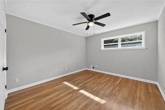a view of a big room with wooden floor and windows