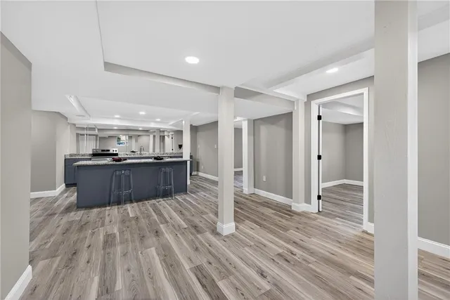 a kitchen with kitchen island wooden floors granite counter and a sink