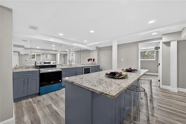 a kitchen with stainless steel appliances kitchen island granite countertop a sink and cabinets