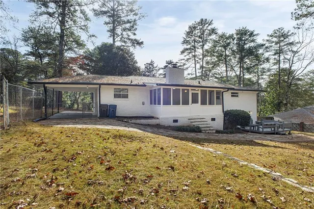 a view of a house with backyard and sitting area