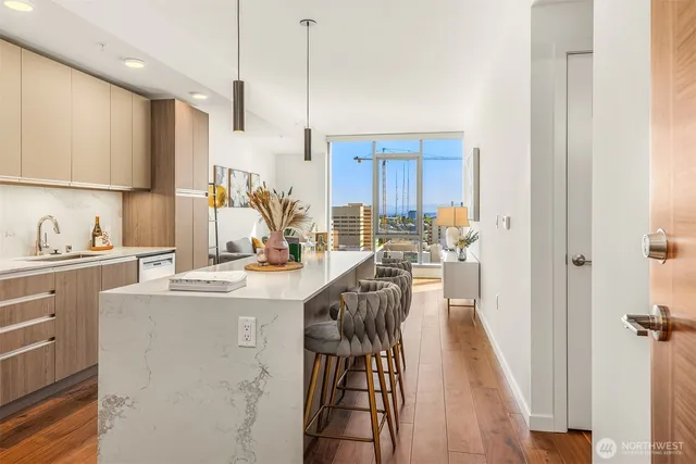 a view of a kitchen with kitchen island granite countertop a sink appliances cabinets and a counter top space