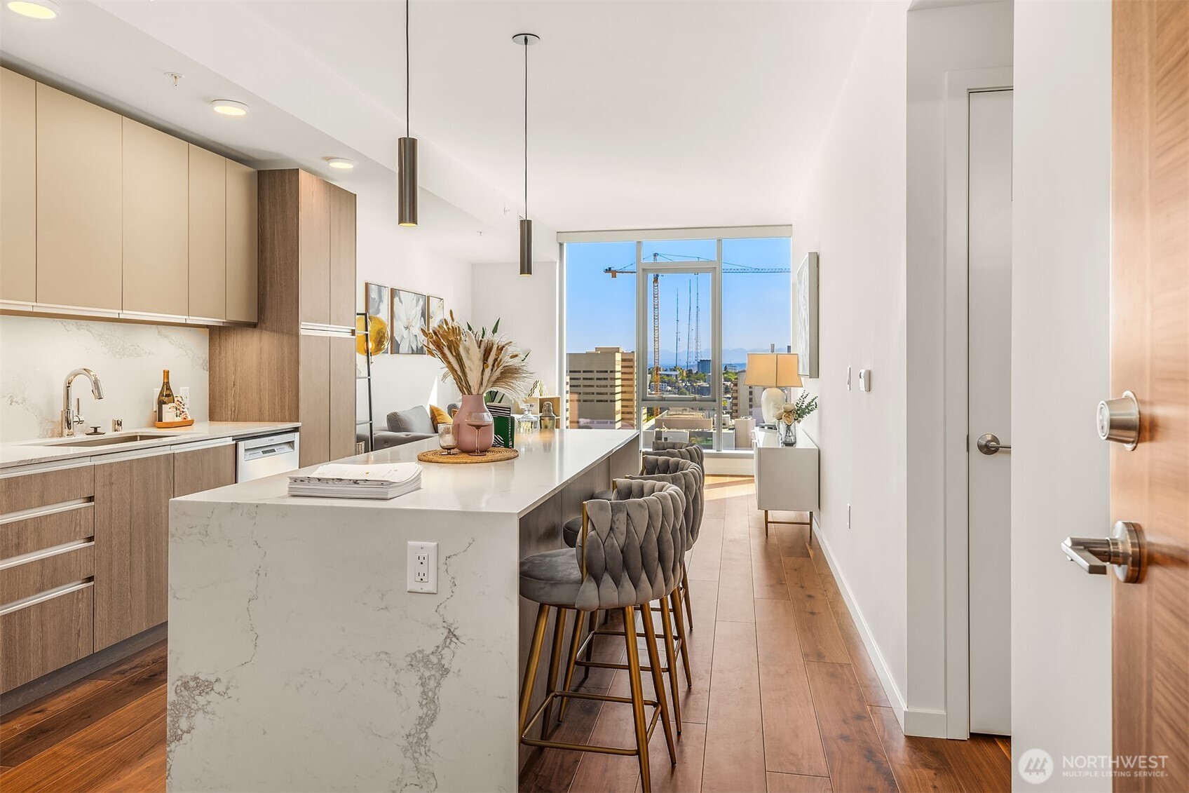 800 Columbia Street, Unit 2307 Seattle, WA 98104 - Photo 5 of 40 a view of a kitchen with kitchen island granite countertop a sink appliances cabinets and a counter top space