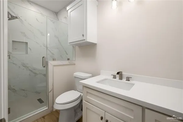 a bathroom with a sink a toilet and shower