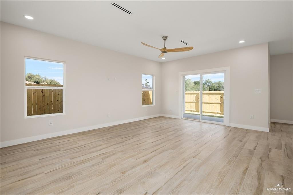 2507 Regina Street Mission, TX 78574 - Photo 2 of 16 an empty room with wooden floor chandelier and windows