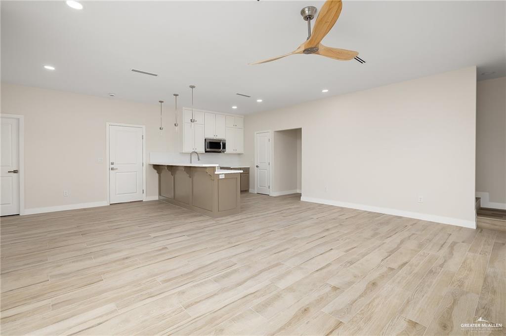 2507 Regina Street Mission, TX 78574 - Photo 4 of 16 a view of kitchen and empty room with wooden floor