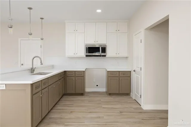 a kitchen with a sink cabinets and wooden floor