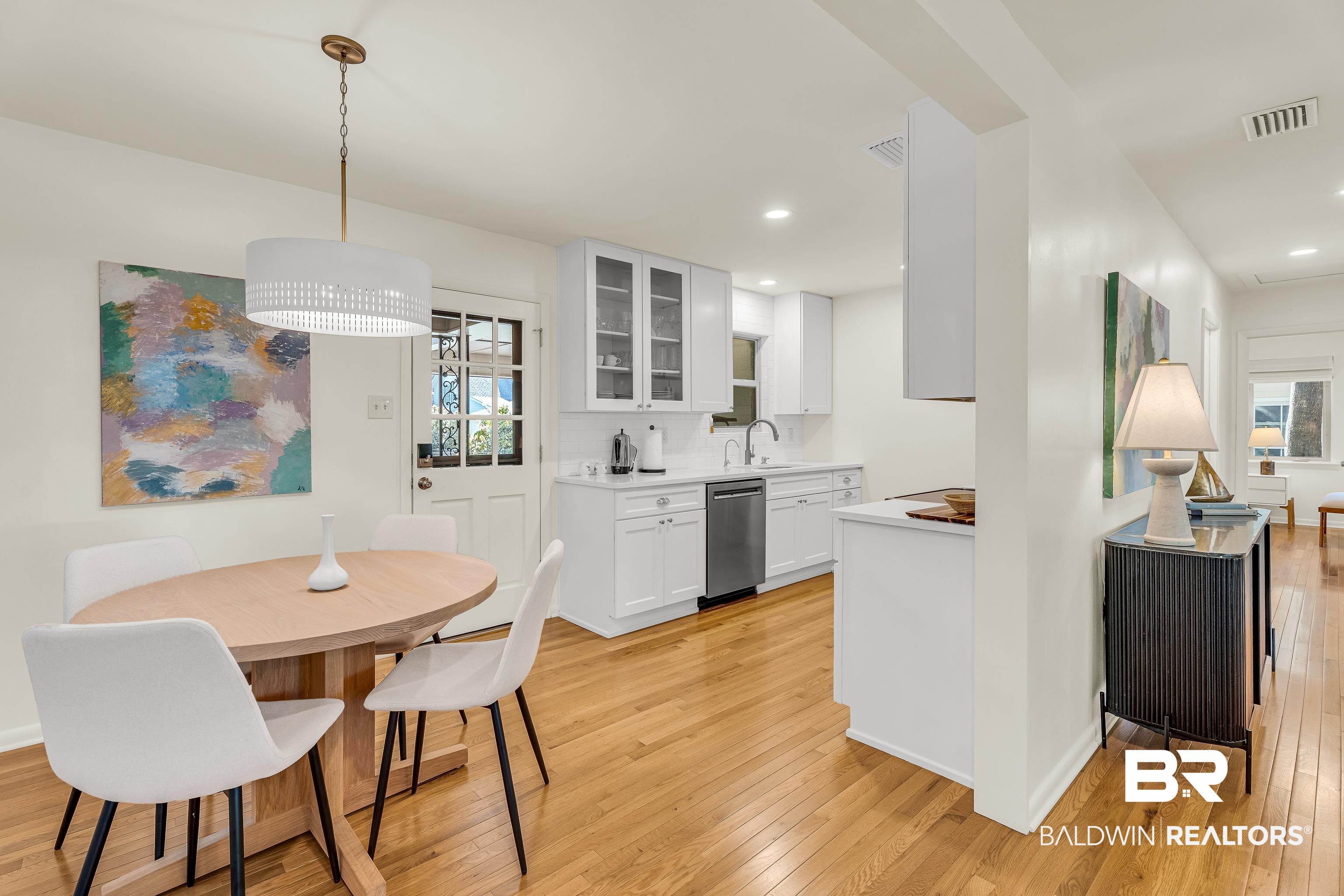 357 Azalea Street Fairhope, AL 36532 - Photo 4 of 22 Kitchen featuring light wood-style floors, glass insert cabinets, pendant lighting, white cabinetry, and stainless steel dishwasher