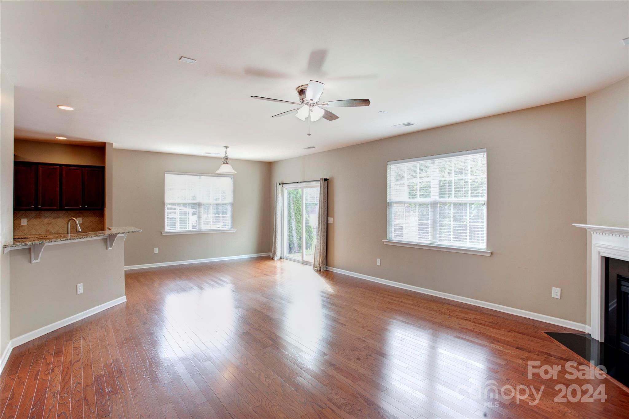 8899 Happiness Road Harrisburg, NC 28075 - Photo 11 of 30 a view of an empty room with a window and wooden floor