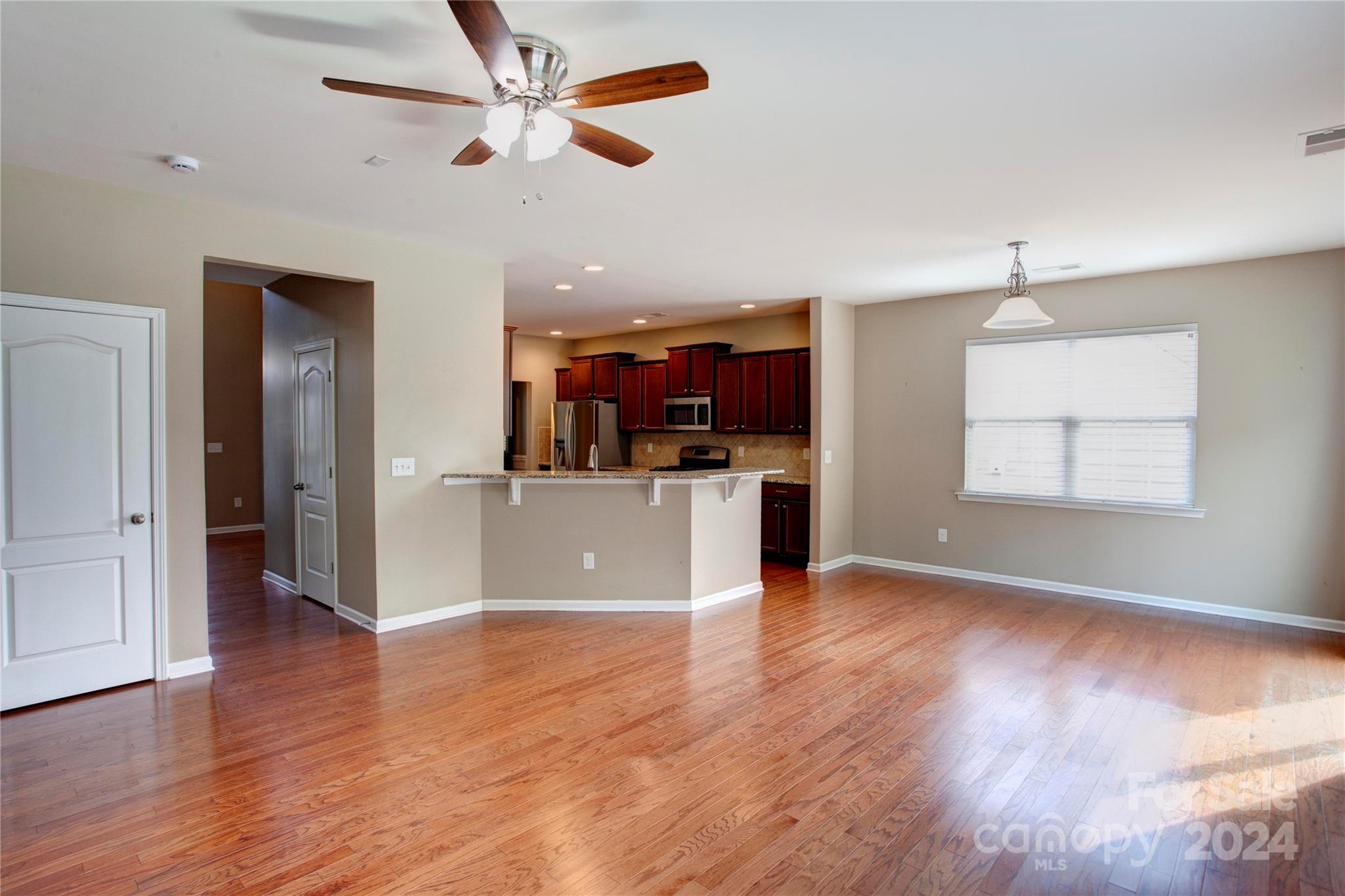8899 Happiness Road Harrisburg, NC 28075 - Photo 12 of 30 an open kitchen with wooden floor and a window