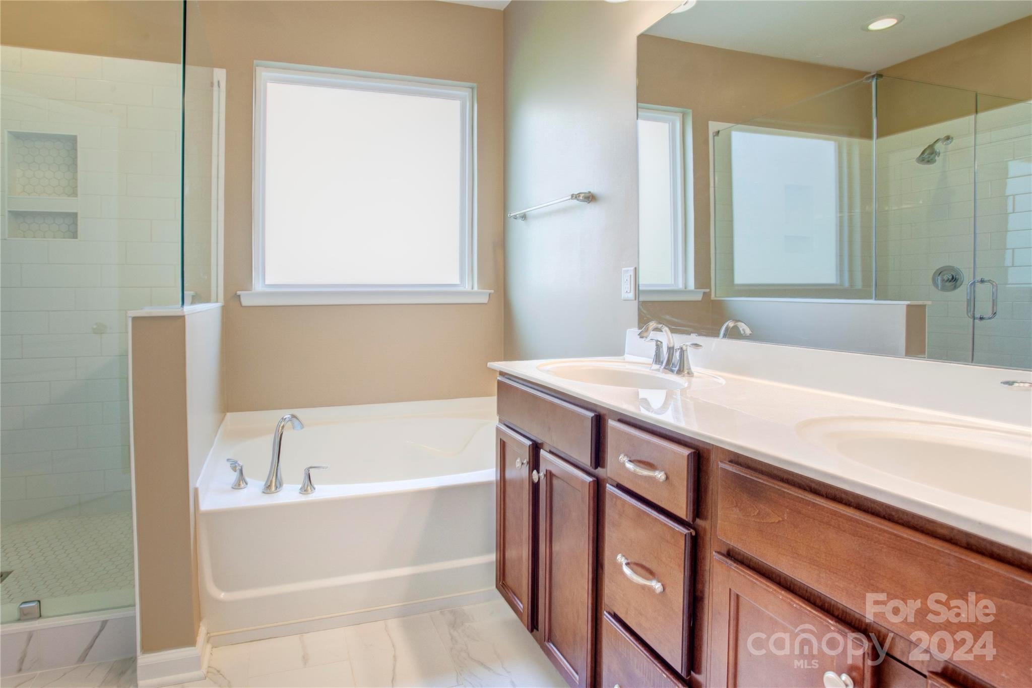 8899 Happiness Road Harrisburg, NC 28075 - Photo 15 of 30 a bathroom with a bathtub and a sink