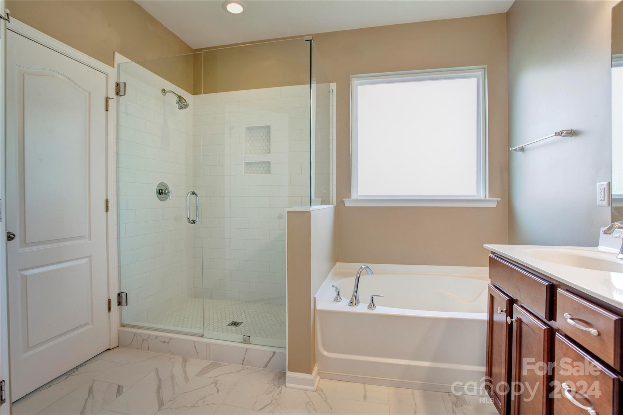 8899 Happiness Road Harrisburg, NC 28075 - Photo 16 of 30 a bathroom with a bathtub shower and toilet
