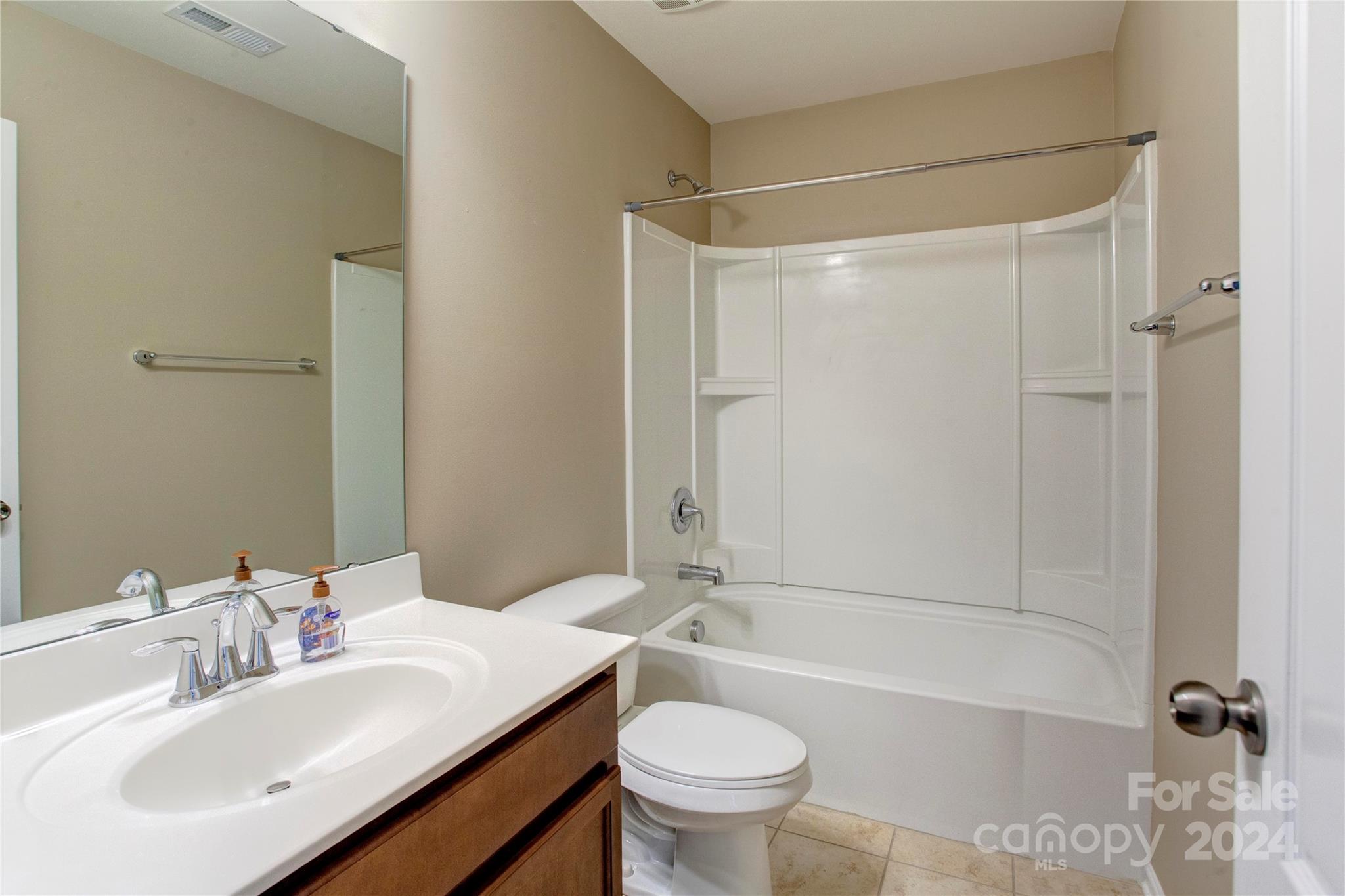 8899 Happiness Road Harrisburg, NC 28075 - Photo 18 of 30 a bathroom with a sink mirror toilet and bathtub
