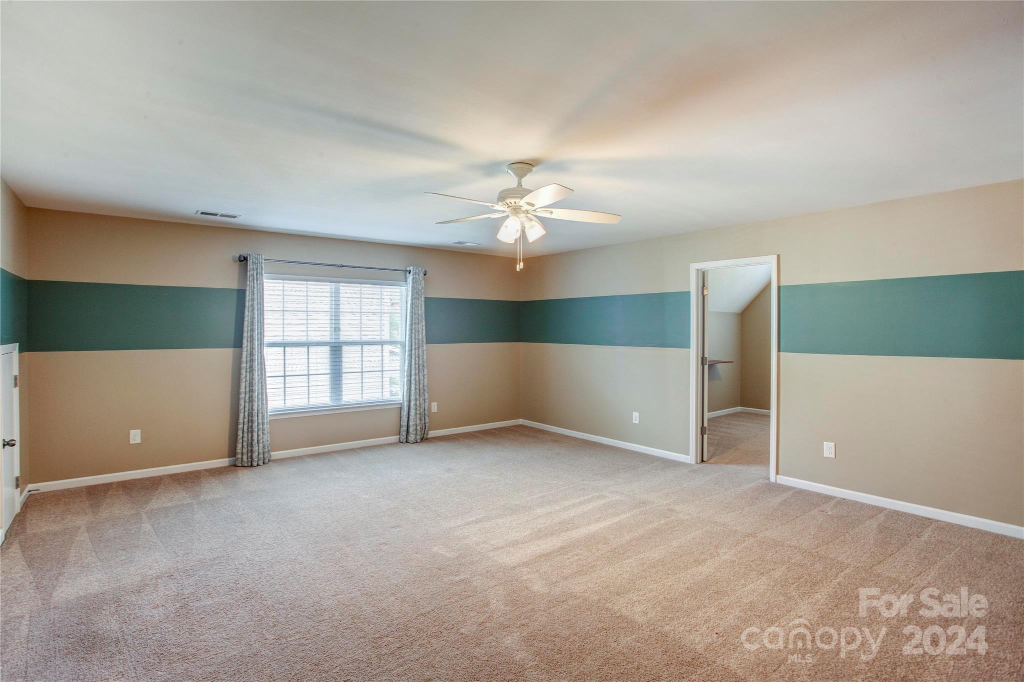 8899 Happiness Road Harrisburg, NC 28075 - Photo 23 of 30 an empty room with windows and ceiling fan
