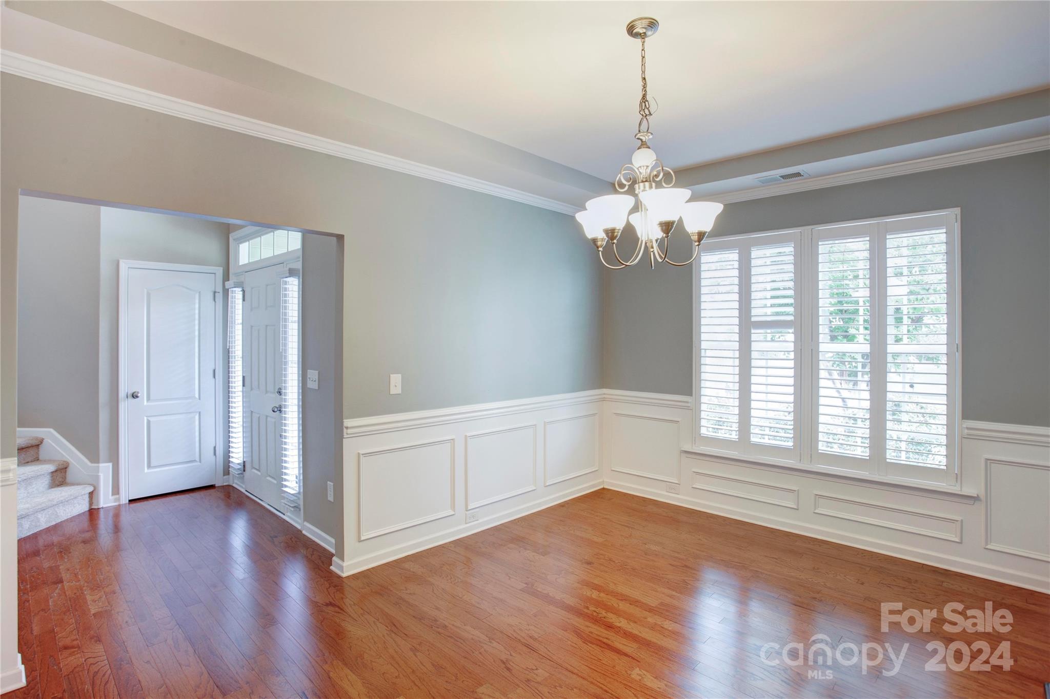 8899 Happiness Road Harrisburg, NC 28075 - Photo 5 of 30 a view of a room with wooden floors and chandelier