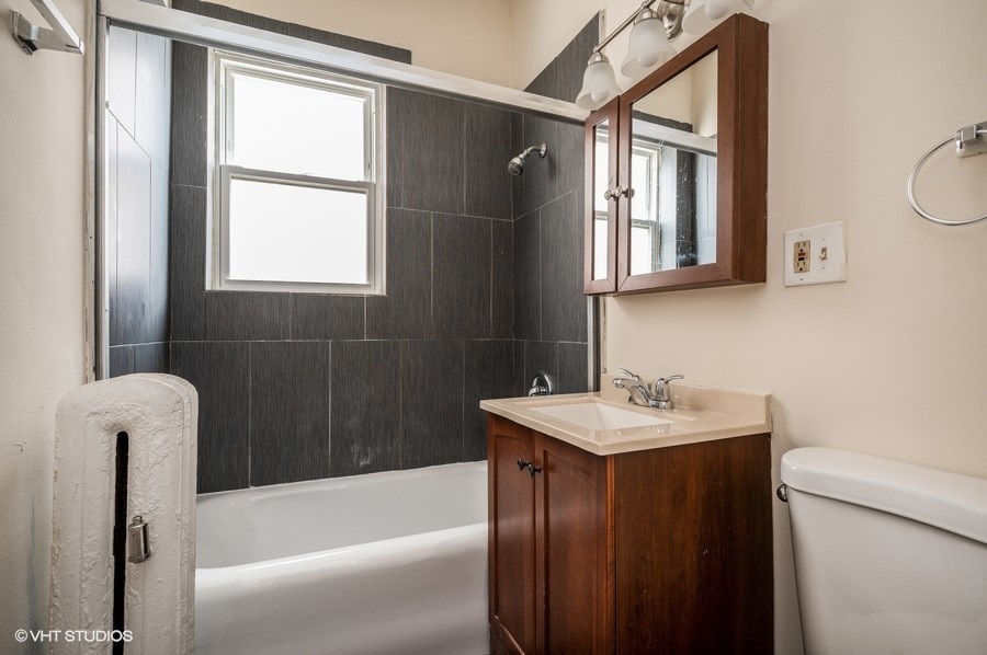 4817 North Springfield Avenue, Unit 1E Chicago, IL 60625 - Photo 3 of 6 a bathroom with a sink a bathtub and a window