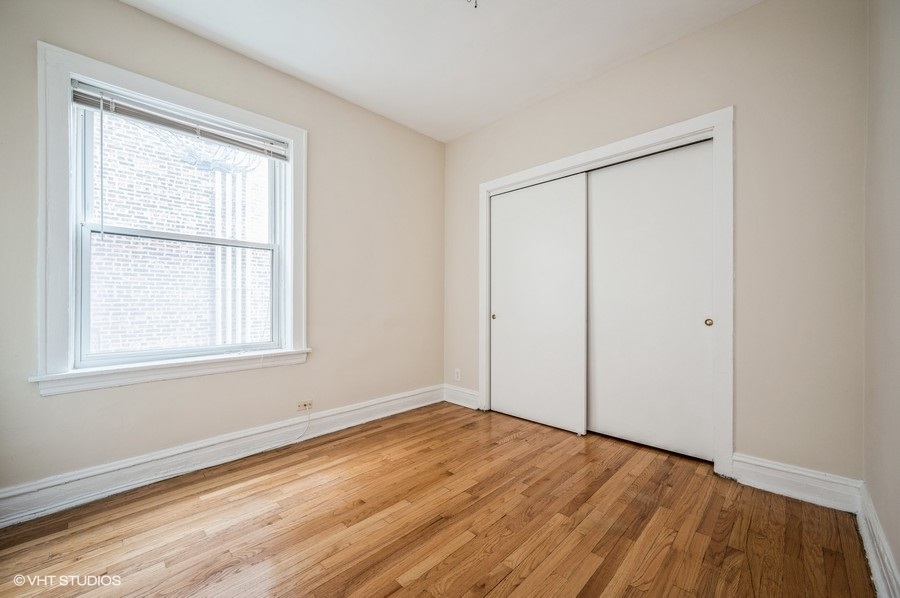 4817 North Springfield Avenue, Unit 1E Chicago, IL 60625 - Photo 4 of 6 an empty room with wooden floor and windows