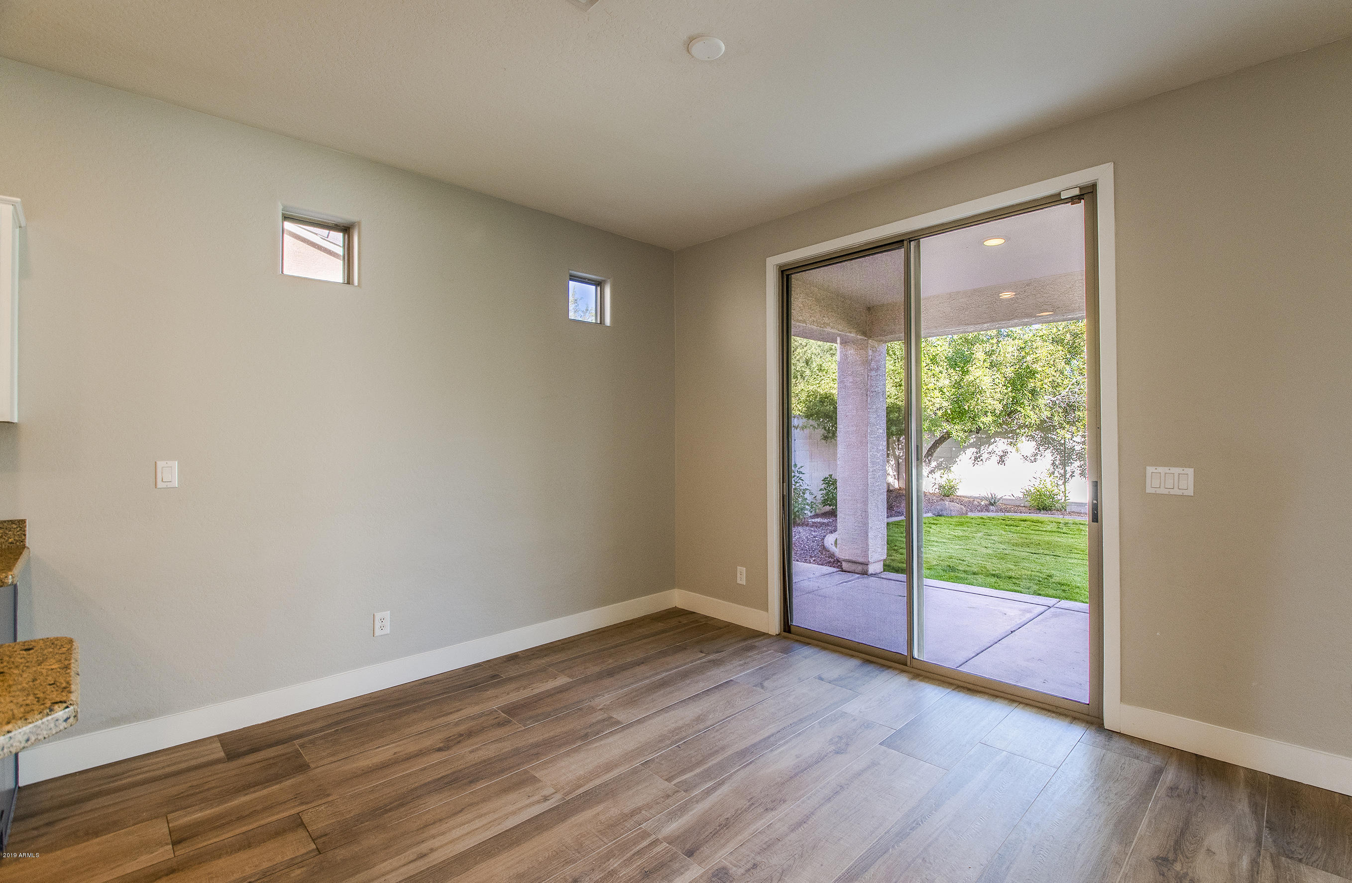 3236 East Phelps Street Gilbert, AZ 85295 - Photo 11 of 29 a view of an empty room with wooden floor and a window