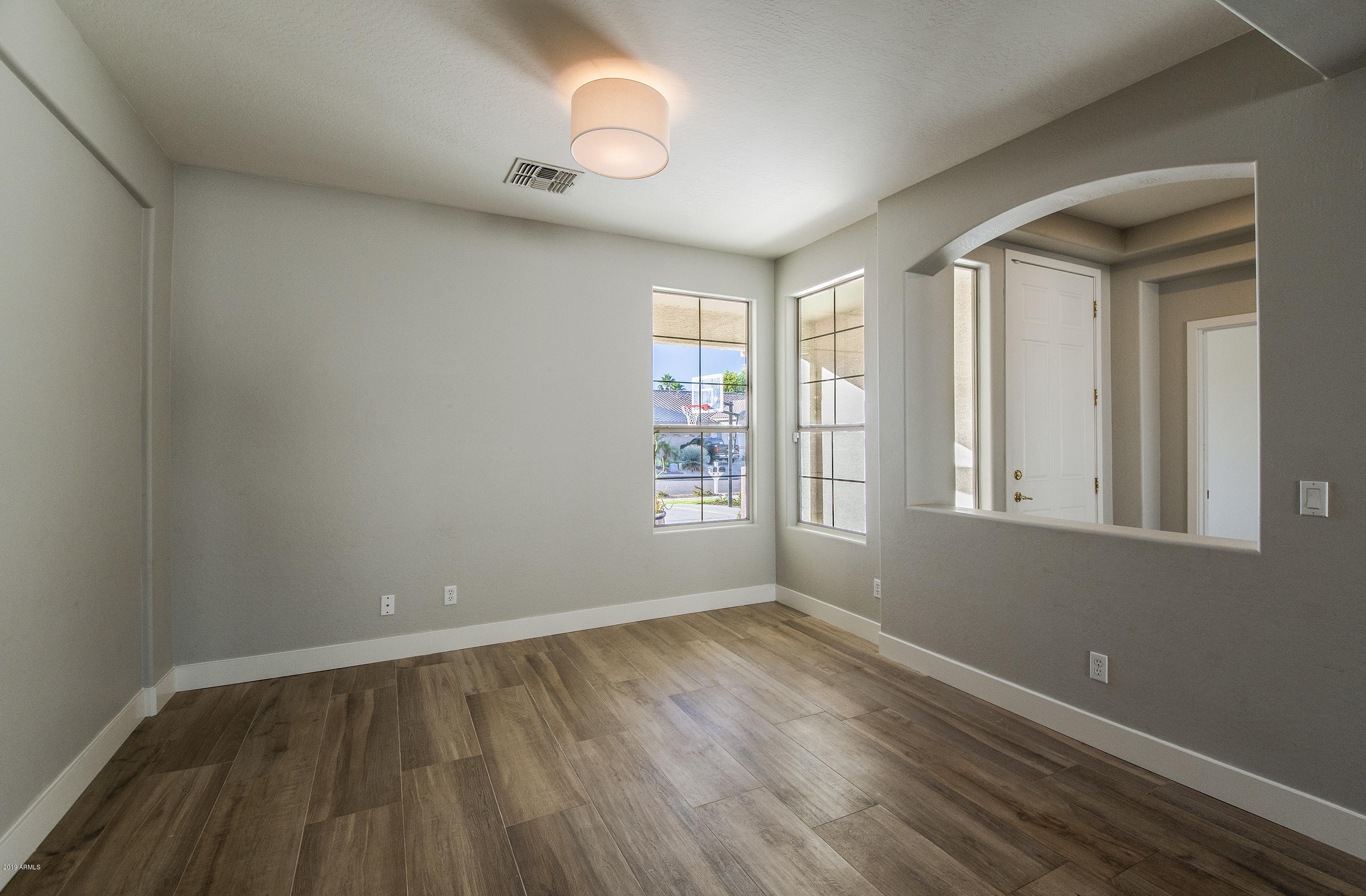 3236 East Phelps Street Gilbert, AZ 85295 - Photo 12 of 29 a view of an empty room with wooden floor and a window